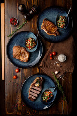 Assortment of juicy appetizing steaks on a wooden table of a fancy restaurant