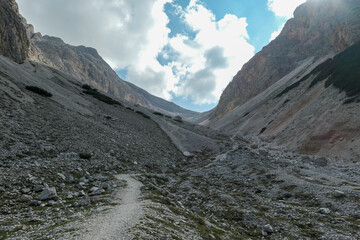 A panoramic view on a stony valley in Italian Dolomites. There are high and sharp mountains around....
