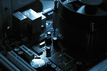 Components on PC circuit board. Chip, fan, capacitor and connectors on the motherboard of a...