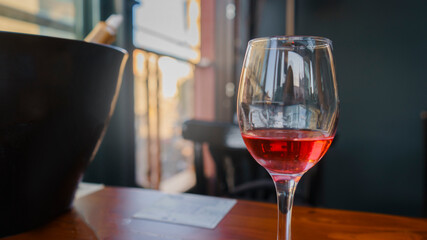 Rose wine is on the bar table. Red wine standing on the restaurant table. 