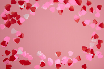 Valentine day composition with copy space. Frame made of confetti hearts red and pink on pastel background. Close up, top view, copy space