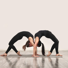 Two slim woman are doing yoga