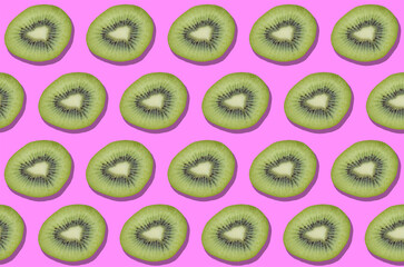 Fototapeta premium Colorful kiwis decorative pattern on pink background. Exotic fruits. Vegan, vegetarian and healthy lifestyle concept. Top view.