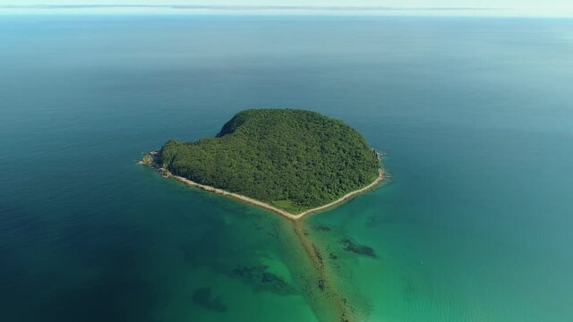 Flight above epic lonely island in middle of blue sea ocean pristine natural landscape. Beautiful seascape. Epic inspirational nature of world. Tropical uninhabited paradise island. Sunny summer film