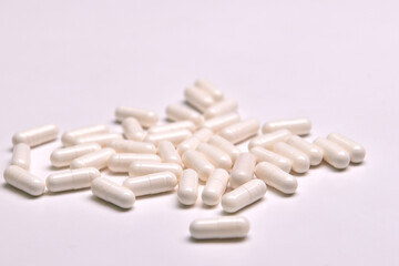 Many white capsule pills on a colorful background. Health supplements and medicines