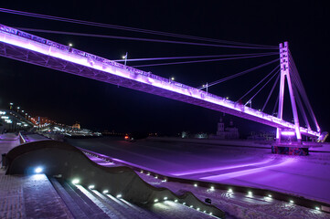 Tyumen, Russia, December 27, 2020: Pedestrian bridge on the embankment at night, in winter