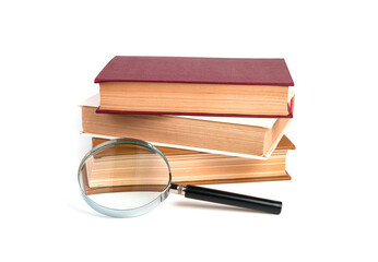 Stack of books, textbooks with magnifying glass isolated on white background.
