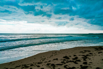 Beautiful areal photo of the sea
waters, horizon, coast, cloudy sky. Storm weather at the ocean backdrop, autumn season on the beach.