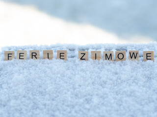 Ferie zimowe - napis z drewnianych kostek, ułożony w śniegu, czas wolny, przerwa zimowa od szkoły, język polski  