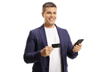 Young handsome man with a wide smile using a credit card for online payment with a mobile phone