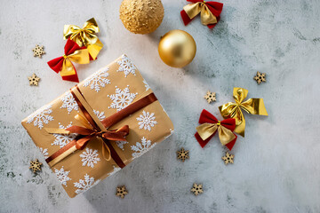 Christmas and New Year concept. A gift in a beautiful package and decorative balls on a gray background.