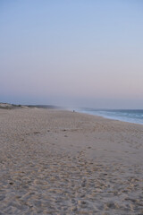 Fisherman fishing on a Comporta empty beach at sunset in Portugal