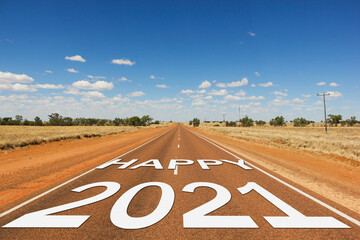 Happy 2021 white text on empty road on a sunny day in the desert in Outback Australia. Road trip to new year, travel concepts. Visionary, celebration, projects, horizon, future symbolism