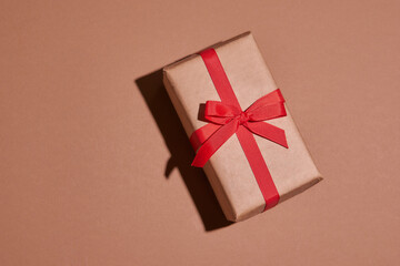 Valentine day composition. Present or gift box wraped in craft paper with heart on pastel background