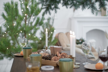 Festive Christmas atmosphere at home in a Scandinavian-style room with candles and a Christmas tree.