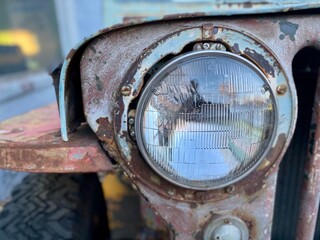 Fototapeta na wymiar Headlight on a vintage rusted truck close-up.