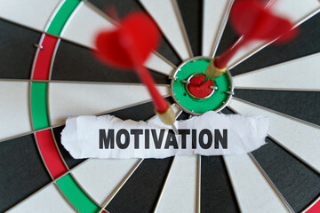 A piece of paper with the text is nailed to the target with a dart - MOTIVATION
