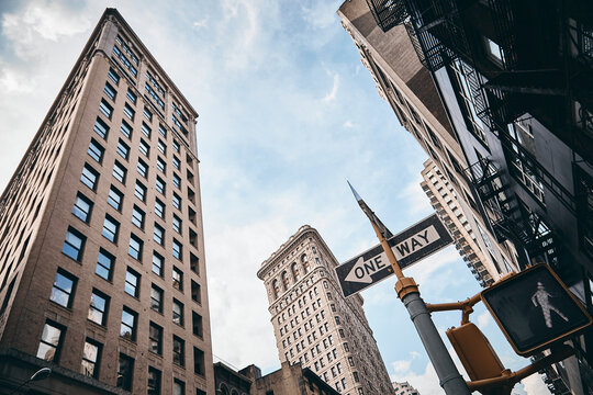 A Low Angle Shot Of The Flatiron Building In Manhattan, New York Against The Cloudy Sky