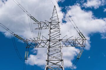 High-voltage power line  close-up against the background of a blue sky with clouds.
