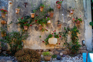 Wall of hanging plant pots with flowers and irrigation systemat the Midrechov Street in Zichron Yaakov Israel