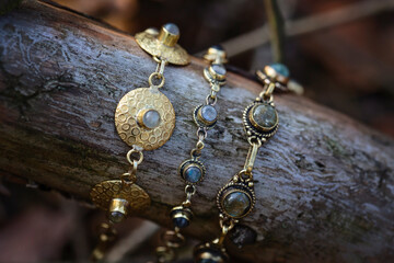 Fototapeta premium Three brass bracelets with labradorite stone on wooden background