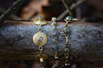 Three brass bracelets with labradorite stone on wooden background