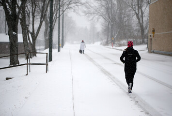 une coureuse dans une rue enneigée en hiver