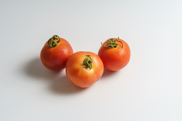 Three ripe tomatoes on white background