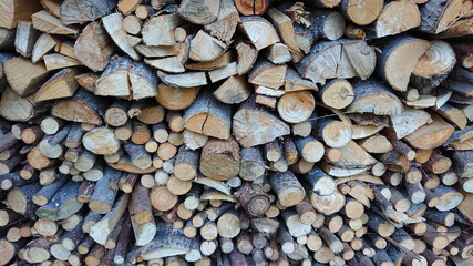 Abstract background with chopped wood in a large heap and stacked in storage piles