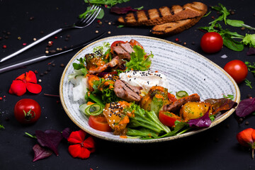 Salad with pork and pumpkin, on a dark background