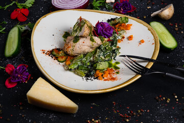 Grilled chicken fillet in the middle with mozzarella and tomatoes, on a pillow of green beans and spinach in cream on a dark background