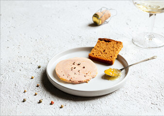 Traditional French foie gras, gingerbread, candied onion in the teaspoon on the white plate on the...