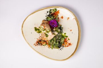 Grilled chicken fillet in the middle with mozzarella and tomatoes, on a pillow of green beans and spinach in cream on a white background