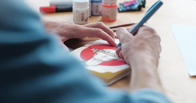 Close Up of Males Hand is drawing some Comix Woman on the Paper. Artist Man is drawing Female Portrait concentrated, enjoying the Process. Creative Person, People Profession. Art. Passion.