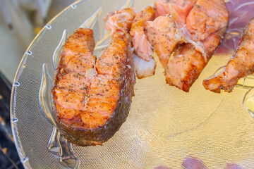 Grilled red fish trout steaks lie on a glass plate