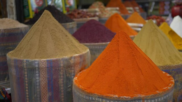 colorful spices sold on eastern outdoor market stall, traditional food, spice bazaar, selling dried herbs