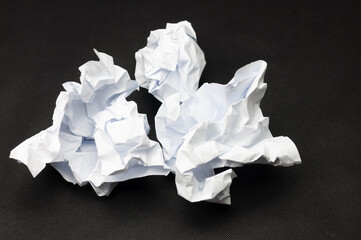 Three crumpled pieces of white paper