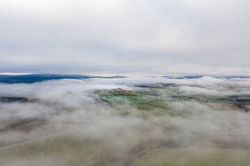 Low cloud lying all over a tolling hill landscape with moody sky