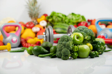 Fitness concept. Healthy nutrition: fruits and vegetables. Equipment for fitness exercises: weighing machine and dumbbells. 