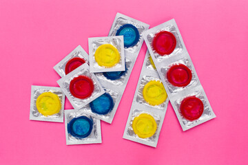 Composition with colorful condoms on bright pink background. Safe sex and contraceptive concept. Flat lay, top view