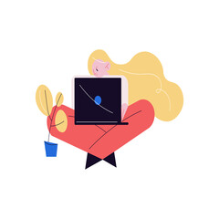 Young woman sitting with laptop on knees and working as programmer