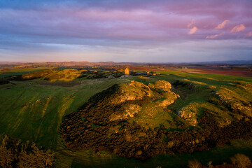 Medieval tower on a hill at sunset with casting light and red skies