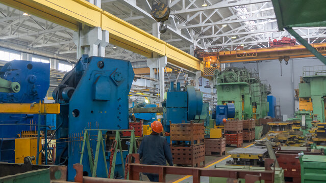 Lifting gear in the workshop at the factory. Yellow overhead crane with linear traverse and hooks in engineering plant shop. Industry concept.
