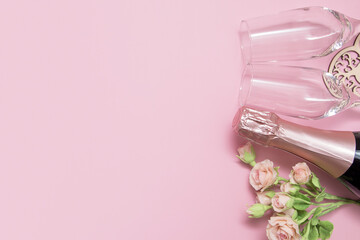 Layout two glasses, champagne, flowers on a pink background with copy space valentine's day date concept