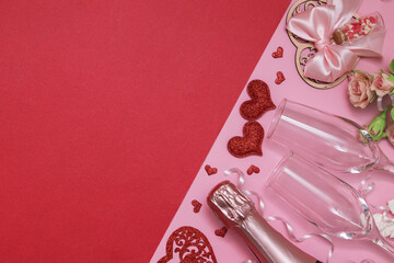 Layout two red hearts, glasses, champagne, flowers on a pink-red background with copy space valentines day date or party concept