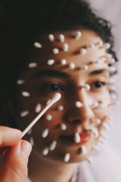 person with q-tips on face 