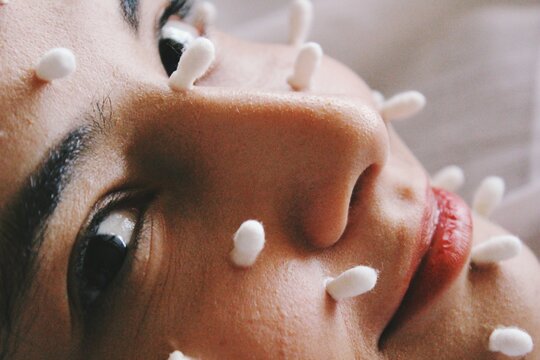 Close up portrait of young woman with q-tips on her face, image about skin care and health 