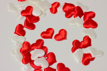 Small red and white hearts that are scattered on a white background.