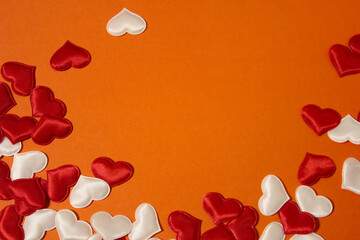 Small red and white hearts scattered on an orange background.