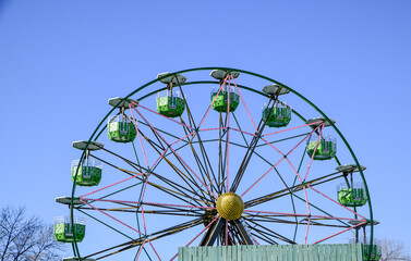 Empty carnival ferris wheel ride against blue sky in winter